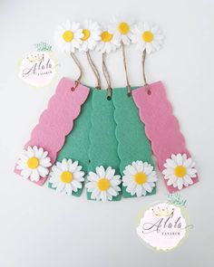 paper flowers are attached to the back of a green and pink dress with white daisies