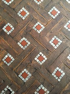 an old brick floor with white and red tiles