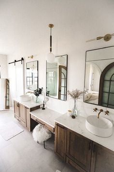 a bathroom with two sinks and mirrors in it