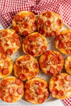 mini pepperoni pizzas on a white plate with red and white checkered cloth