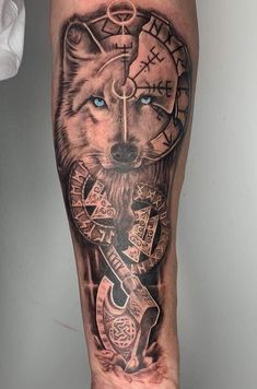 a man's leg with a wolf and compass tattoo on it