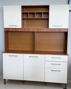 a white cabinet with wooden doors and drawers