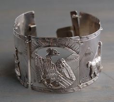 A large vintage 1940's sterling silver Peruvian link cuff bracelet, with Inca and llama relief design, presented by MintAndMade. This wide, intricate cuff bracelet consists of five links depicting Peruvian themes, such as llamas, mountains, Incan bird and two figures in traditional garb. It has a lovely vintage patina, but let me know if you would like me to polish it. It is in good vintage condition, however, the clasp is slightly bent. It still opens and closes just fine. Please feel free to c Relief Design, Mint Tins, Silver Turquoise Jewelry, Shine Bright Like A Diamond, Bracelet Vintage, Sea Glass Jewelry, Ethnic Jewelry, Vintage Bracelets, Vintage Shop