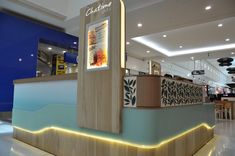 the interior of a restaurant with blue walls and white flooring, lit up by neon lights