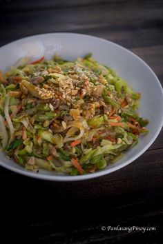 a white bowl filled with salad on top of a wooden table