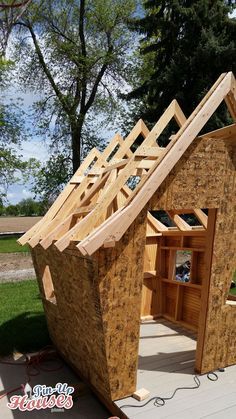 a house being built in the yard with wood framing and roof trussing on it