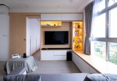 a living room filled with furniture and a flat screen tv sitting on top of a wall