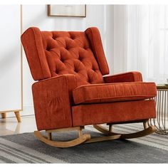 an orange rocking chair sitting on top of a rug