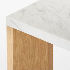 a white marble top and wooden base on a table or bench with light wood grained edges