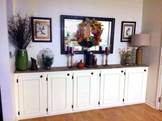 a room filled with white cabinets and vases