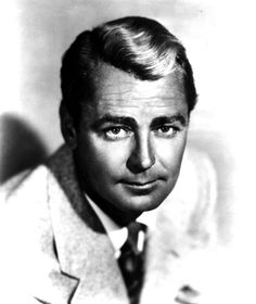 an old black and white photo of a man in a suit looking at the camera