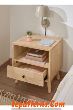 a nightstand with books and a plant on it