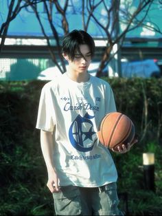 a young man holding a basketball in his hand