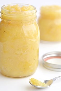 a jar filled with yellow liquid next to two spoons