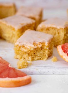 slices of cake with frosting and grapefruit on top