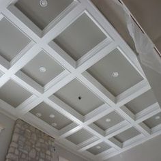 an empty room with white ceiling and stone fireplace