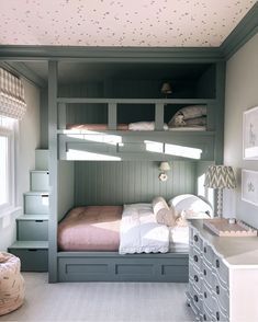 a bedroom with bunk beds and drawers in it