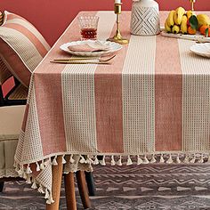 a dining room table set for two with plates and glasses on top of the table