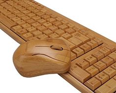 a wooden computer keyboard with a mouse on it