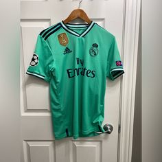 a green soccer jersey hanging on a door