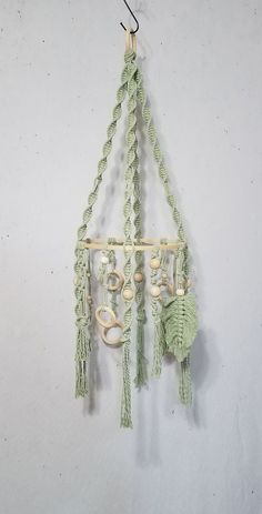 a green macrame hanging from a hook on a wall