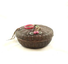 a wicker basket with scissors and other items on it sitting on a white surface