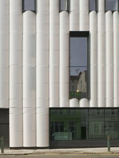 a tall white building sitting next to a street