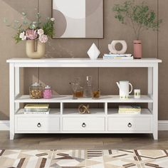 a white table with drawers and vases on top