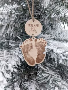 a wooden ornament hanging from a tree with footprints on it's side