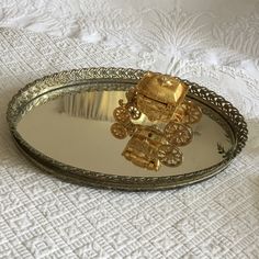 a gold teddy bear sitting on top of a silver tray next to a white tablecloth