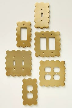 four different types of metal switchplates on a white surface with one light switch plate in the middle