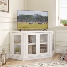 a flat screen tv sitting on top of a white cabinet