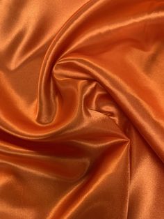 "60\" wide luxurious orange charmeuse satin fabric is a beautiful lightweight soft and smooth with a silk like appearance and feel, drapes nicely and made with 100% polyester fibers. Great for party decor, backdrops, blouses, apparel, lingerie, lining, chair sashes, curtains, tablecloths, linens, overlays, and much more. Sold by the yard continuous up to the length of the roll. For instance an order of 1 yard (Qty=1) is 60\" x 36''. Order of 3 yards (Qty=3) is 60\" x 108''. Color can vary by dye Charmeuse Fabric, Orange Satin, Chair Sashes, Burnt Orange Color, Burlap Fabric, Luxury Aesthetic, Muslin Fabric