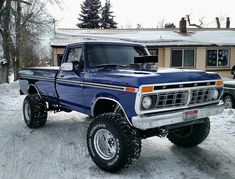 a blue truck is parked in the snow