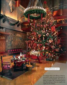 a decorated christmas tree in the middle of a room with red chairs and other decorations