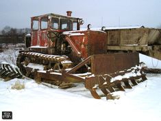 an old bulldozer sitting in the snow with it's front end broken