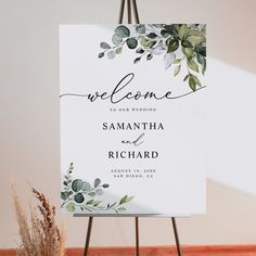 a welcome sign with greenery on it and the words, welcome to our wedding