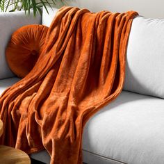 an orange blanket draped over a white couch