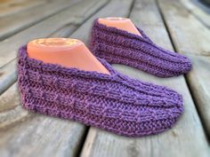 a pair of purple slippers sitting on top of a wooden table