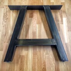 a black metal stool sitting on top of a wooden floor