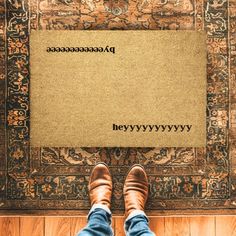 a person standing in front of a rug with the word's written on it