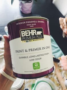 a person holding a can of paint in their hand