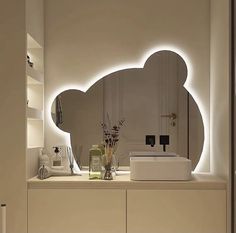 a bathroom with a large mirror and lights on the wall next to it's counter