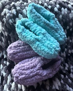 three pieces of blue, purple and white knitted material on top of each other