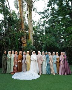 a group of women standing next to each other on top of a lush green field