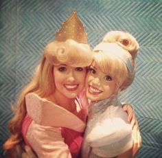 two barbie dolls hugging each other with a crown on their head