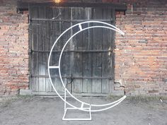 a white sculpture sitting in front of a brick wall next to a wooden garage door