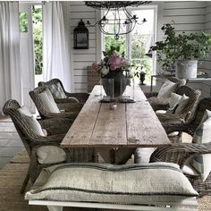 a dining room table with chairs and a bench in front of the window that is open