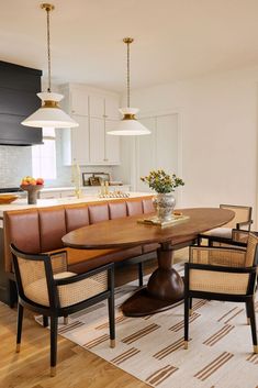 a dining room table surrounded by chairs and lights