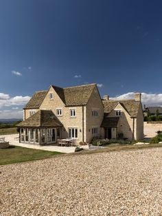 a large house sitting on top of a gravel covered field